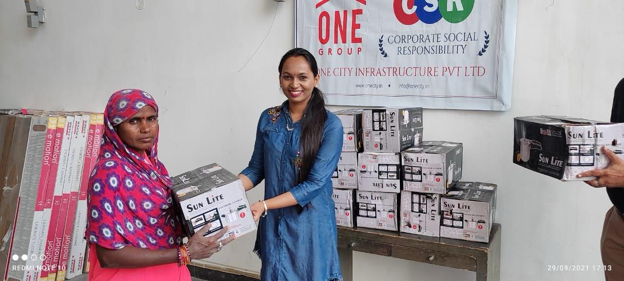 A woman receiving a household essentials box at a CSR drive