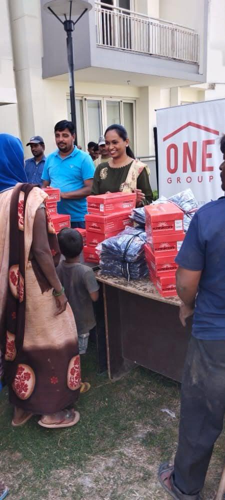 Team members handing out kits beside a ONE Group banner