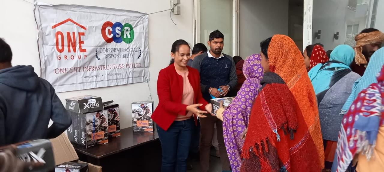 Women receiving household essentials at a CSR drive