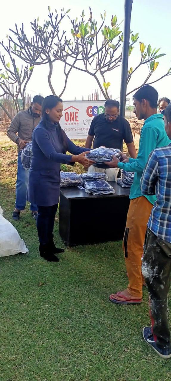 A worker receiving warm clothing from the foundation team
