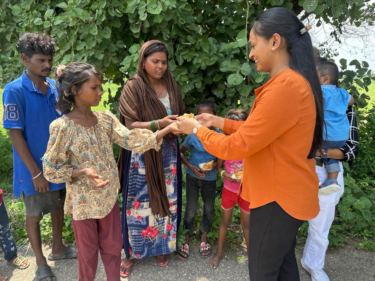 A foundation volunteer sharing sweets with a young girl and her family