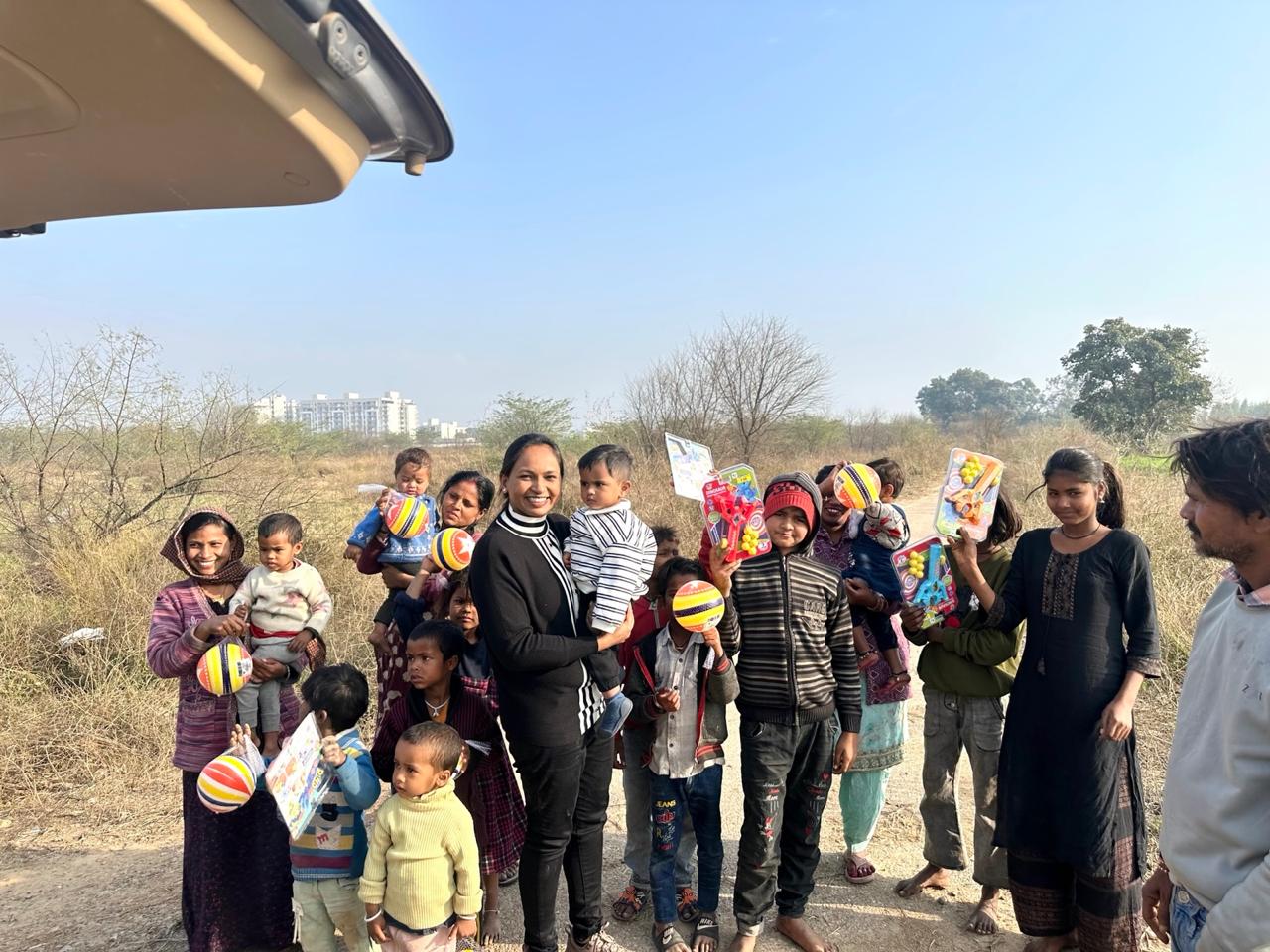Children and mothers smiling with toys in an open field